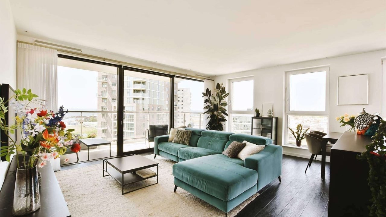 a-living-room-with-a-green-couch-and-large-windows-2025-02-10-11-14-02-Q83UQRM.jpg
